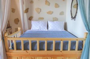 a bedroom with a wooden bed with a blue comforter at Villa Limnioni in Archangelos