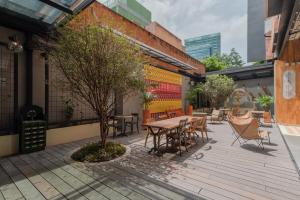 a patio with tables and chairs and a tree at Masaya Medellin in Medellín