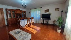 a living room with a table and a television at CASA LA REVERENDA in Barcia