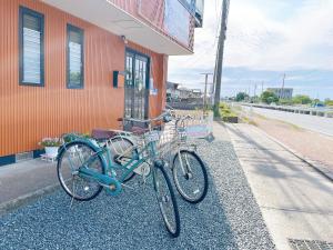 Guesthouse Ise Futami في إيسي: اثنين من الدراجات متوقفة على جانب المبنى