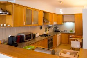 cocina con armarios de madera y microondas en Ericeira (S. Lourenco) Apartment, en Ribamar