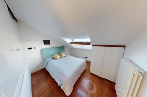 a small attic bedroom with a bed and a radiator at WELCOME RIVIERA - ATTICO SAN FAUSTINO 165 mq più 110 mq di terrazza- IN VILLA 700 ,VISTA MARE STREPITOSA-100 m dalla spiaggia-PARKING ESCLUSIVO in Rapallo