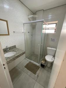 a bathroom with a shower and a toilet and a sink at Hotel Itu Shopping in Itu