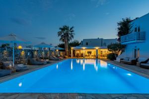 a swimming pool lit up at night in a hotel at Dionysos Luxury Hotel Mykonos in Ornos