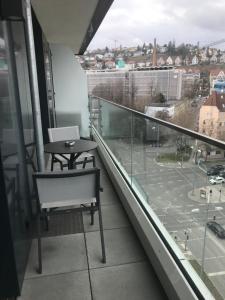 a balcony with a table and a view of a city at Sky Aparthotel in Stuttgart