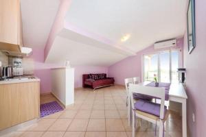 uma cozinha com paredes roxas e uma mesa e cadeiras em Apartment in Zaton (Zadar) with Terrace, Air conditioning, Wi-Fi, Washing machine (4814-3) em Zaton