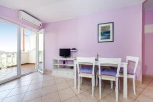 uma sala de jantar com mesa e cadeiras e uma televisão em Apartment in Zaton (Zadar) with Terrace, Air conditioning, Wi-Fi, Washing machine (4814-3) em Zaton