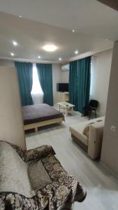 a bedroom with two beds and a couch and a television at Sanpic in Sanzhiyka