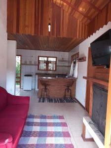 a living room with a red couch and a fireplace at Claire Cottage in Monte Verde