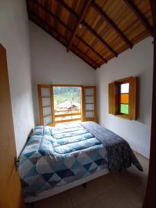 a bedroom with a bed in a room with a window at Claire Cottage in Monte Verde