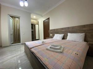 Un dormitorio con una cama grande con toallas. en Family Hotel, en Batumi