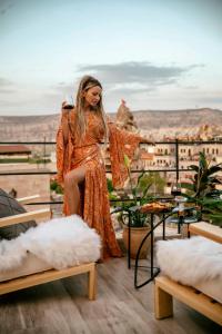 a woman in an orange dress sitting on a table at Sato Cave Hotel in Göreme