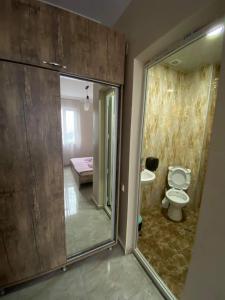 a bathroom with a toilet and a glass door at Family Hotel in Batumi