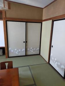 um quarto com três janelas e uma mesa e cadeiras em Suijin Hotel - Vacation STAY 38314v em Chichibu
