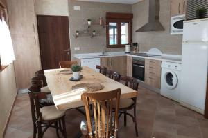 a kitchen with a wooden table and chairs in a kitchen at La Morada de los Olmos in Segovia