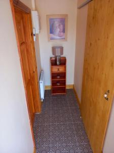 a hallway with a wooden door and a dresser at A New U Country Cottage Apartment 2 in Valentia Island