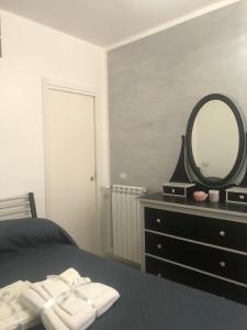 een slaapkamer met een bed met een spiegel en een dressoir bij Palinuro Centro in Palinuro