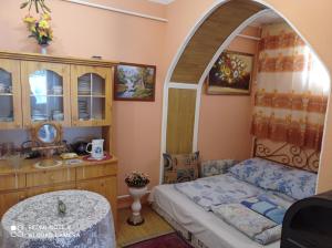 a small bedroom with a bed and an archway at Olga Vendégház in Abádszalók