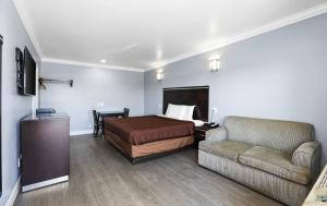 Habitación de hotel con cama y sofá en 3rd Avenue Inn, en La Habra