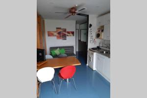 a kitchen with a table and two red chairs at Estudio en la Pineda todo en un ambiente cerca de Port Aventura in La Pineda
