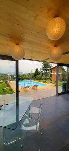 a glass table and chairs in a house with a pool at ConfinedeiSanti B&B in Moriondo Torinese