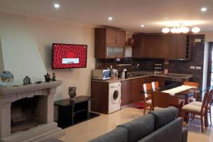 a kitchen and living room with a couch and a fireplace at Casa Bento Moura Portugal in Moimenta da Serra