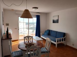 a living room with a table and a blue couch at CASTELLSOL ARENAL HOME BEACH in Punta Grossa