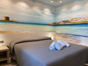 a bedroom with a bed with a painting of the ocean at 103 Boutique Hotel Stintino in Stintino