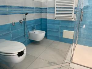 a blue and white bathroom with a toilet and a shower at 103 Boutique Hotel Stintino in Stintino