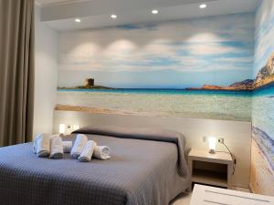 a bedroom with a painting of the ocean and a bed at 103 Boutique Hotel Stintino in Stintino
