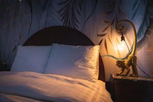 ein Bett mit einer Lampe und einem ausgestopften Tier auf einem Nachttisch in der Unterkunft 'tBegijnhof in Gent