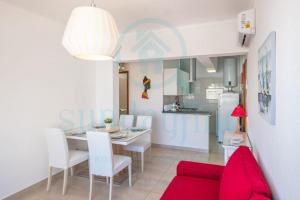 een woonkamer met een tafel en een rode bank bij Apartment Algarve - Beach Front - Free Wifi - Air Con in Armação de Pêra