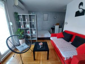 - un salon avec un canapé rouge et une table dans l'établissement Studio IKA, à Ledine