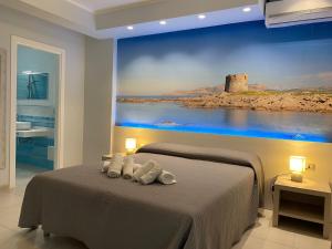 a bedroom with a bed with a painting on the wall at 103 Boutique Hotel Stintino in Stintino