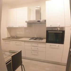 a white kitchen with a stove and a microwave at HYDROSUITE in Genoa