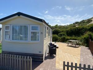 a tiny house with a picnic table and a bench at Chalet Playa direct aan zee in IJmuiden in IJmuiden