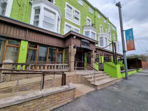 un bâtiment vert avec des escaliers en face de celui-ci dans l'établissement The Lawton, à Blackpool