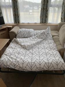 łóżko z dwoma poduszkami w salonie w obiekcie Chalet Playa direct aan zee in IJmuiden w mieście IJmuiden