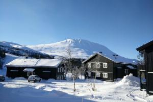 una casa nella neve con una montagna sullo sfondo di Apartment Gaustablikk a Gaustablikk