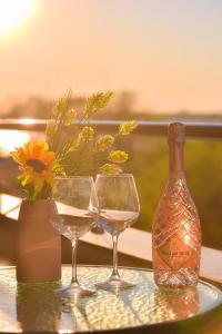 ママイアにあるApartment Summerlandの花のテーブルに置いたグラス2杯とボトル1本