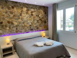 a bedroom with a bed with two towels on it at 103 Boutique Hotel Stintino in Stintino