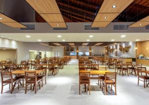 uma grande sala de jantar com mesas e cadeiras em Ondas Praia Resort All Inclusive em Porto Seguro