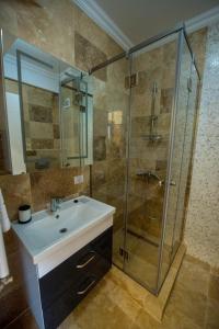 a bathroom with a sink and a glass shower at Apartments in Solid House Mamaia in Mamaia