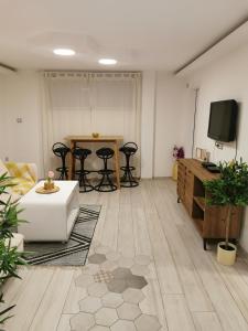 a living room with a table and chairs and a television at Apartman Tea in Novi Sad