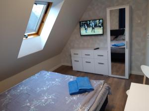 グダニスクにあるPokoje, apartament NA WYSPIEのベッドルーム1室(ベッド1台、壁にテレビ付)