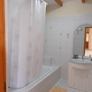 a bathroom with a tub and a shower curtain at Pitypang Vendégház Villány in Villány