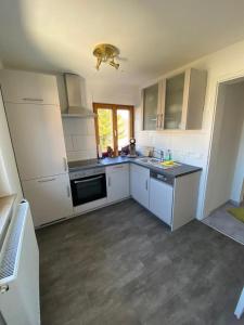 a kitchen with white cabinets and a stove top oven at Ferienwohnung Sonnenhang 3 in Albstadt