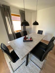 una mesa de comedor con sillas negras en una habitación en Ferienwohnung Sonnenhang 3 en Albstadt