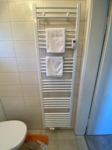 a bathroom with a towel rack with white towels at Ferienwohnung Sonnenhang 3 in Albstadt