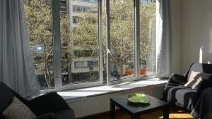 een woonkamer met een aantal ramen en een tafel bij Belga Apartment 3 bedrooms. in Antwerpen